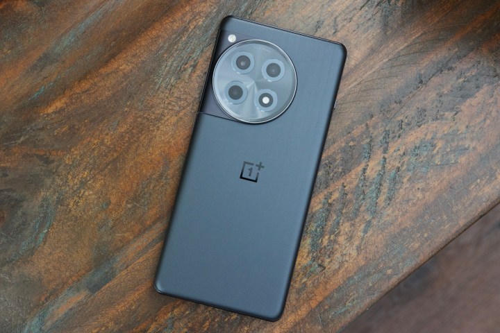 Un OnePlus 12R negru intins cu fata in jos pe o masa.
