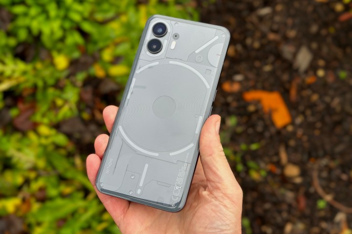 O persoana care tine telefonul Nothing Phone 2, aratand panoul din spate.