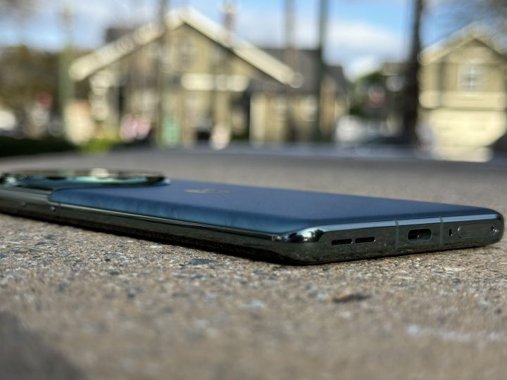 OnePlus 12 Flowy Emerald inclinat pentru a afisa partea inferioara plata.