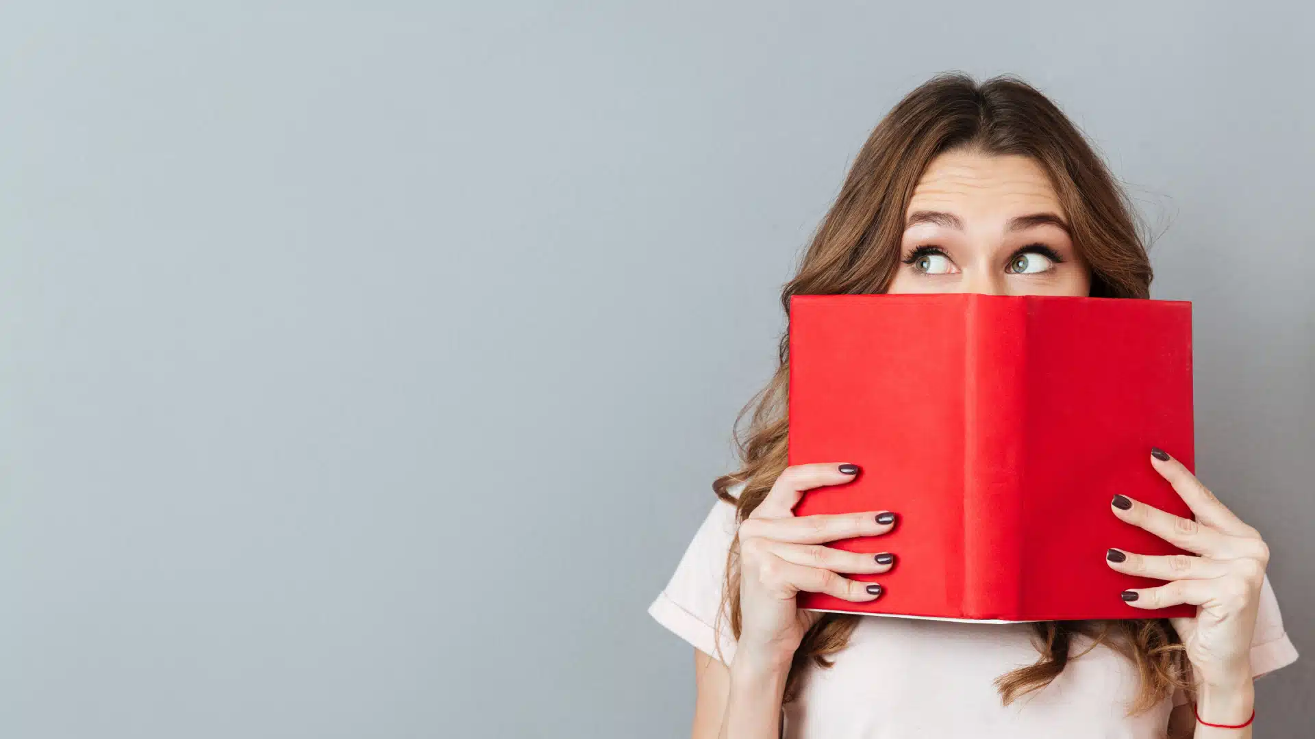 femeie tinand o carte in fata fetei, cu ochii indreptati spre stanga